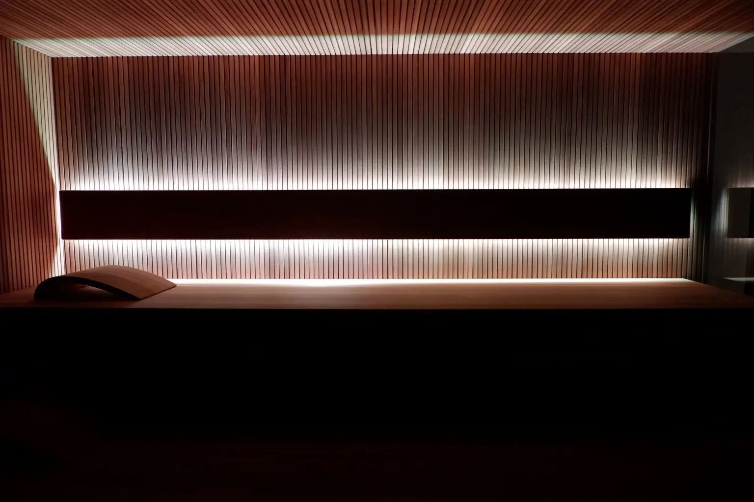 Podświetlana ściana i ławka w nowoczesnej saunie